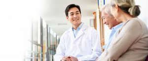 smiling doctor discussing with a couple of patients